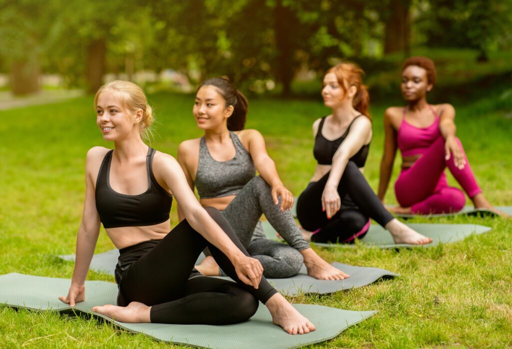 group of multinational women attending outdoor yoga practice at park.jpg